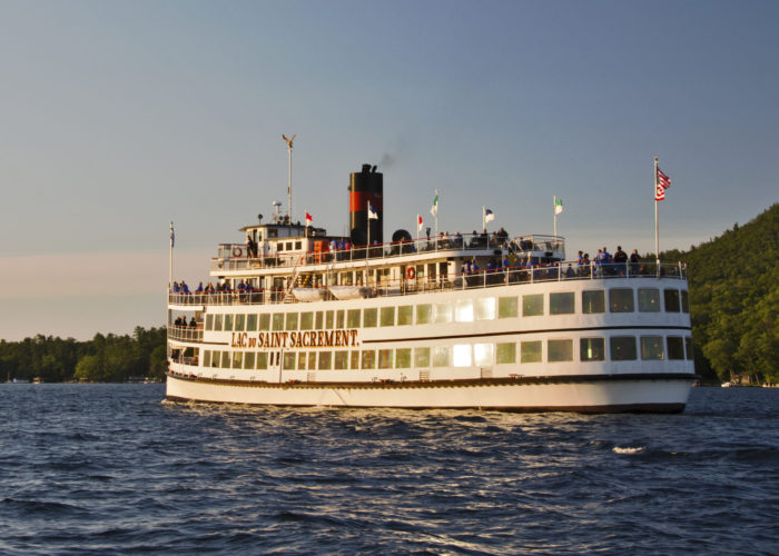 A picture of the saint with many people on deck as she sails the lake